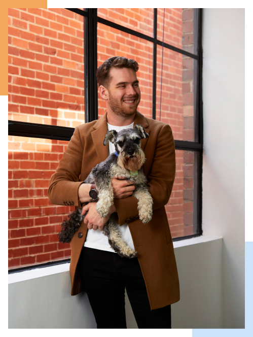Harry Sanders, founder of StudioHawk and Hawk Academy, holding Basil the office dog